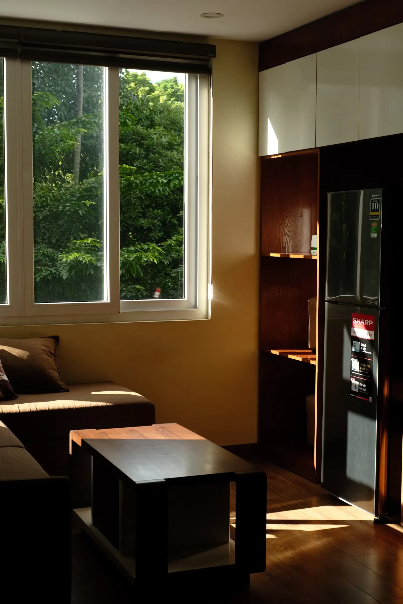 Interior designer arranging emerald and ivory furnishings in a sunlit studio room